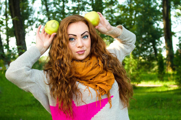 漂亮的<strong>姜黄色</strong>头发的女人拿着苹果，户外肖像