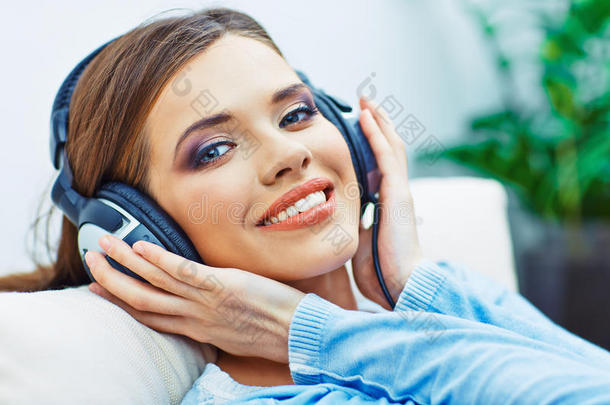 快乐微笑的女人用耳机听<strong>音乐</strong>
