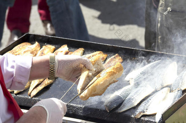 伊斯坦布尔-5月2日：2014年5月2日，伊斯坦布尔，一名土耳其男子在埃米诺努向游客出售<strong>烤鱼</strong>。在街上吃饭是爸爸