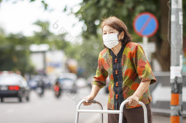 中国老年妇女戴口罩保护空气污染。