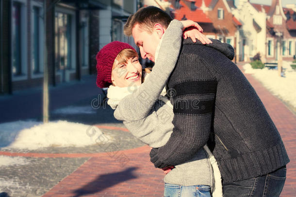 一对年轻夫妇在冬天在城里走来走去。