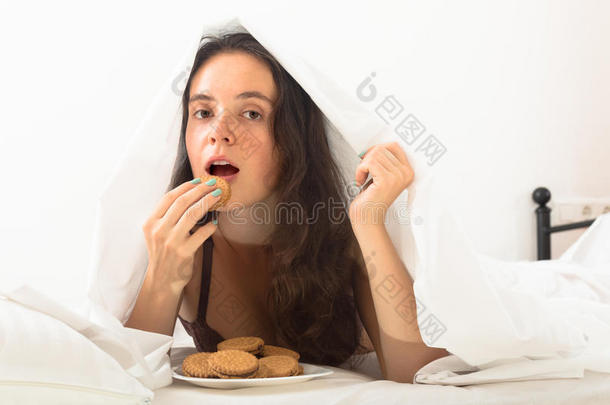 女孩在床上吃饼干