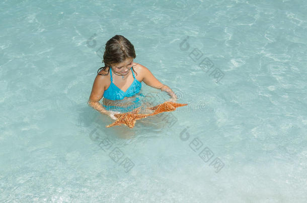孩子在湛蓝清澈宁静的海洋里玩海星