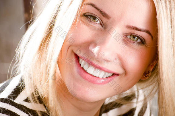 特写图片美丽的金发年轻女子开心的微笑展示伟大的牙齿美白