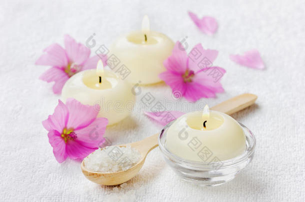 水疗组合，木勺海盐浴，粉色花朵和燃烧的蜡烛