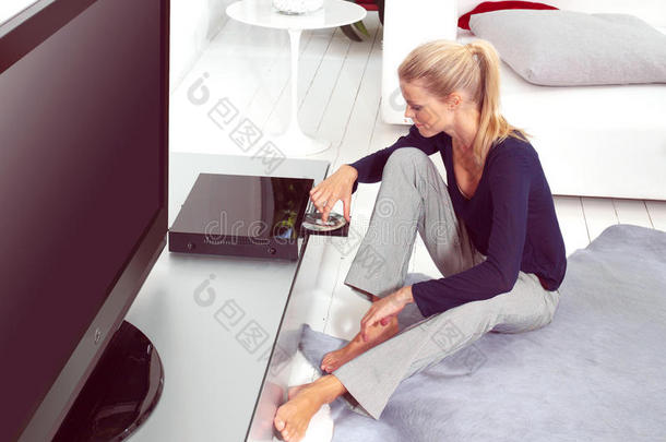 在公寓里用dvd播放机的女人