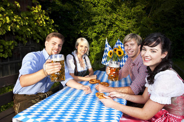 四个年轻人拿着啤酒杯和啤酒杯