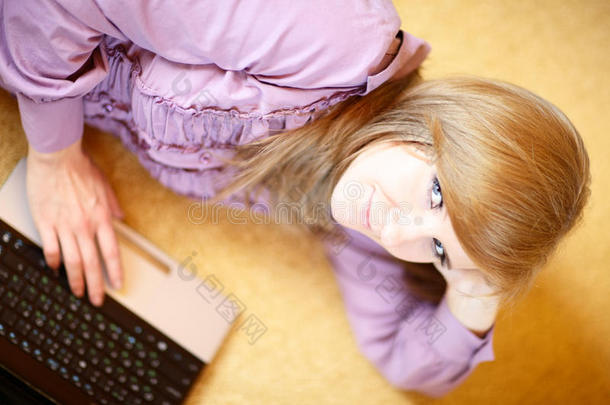年轻的白人妇女<strong>在家</strong>里用笔记本电脑（<strong>上网</strong>本）俯视拍摄。