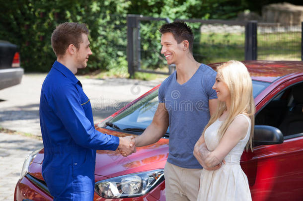 汽车修理工与情侣握手
