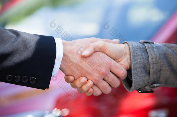 汽车经销商与女客户在经销商处握手