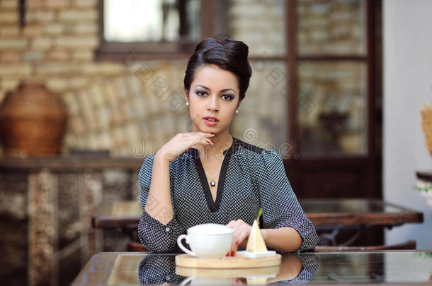 年轻漂亮的女人在餐厅喝茶会