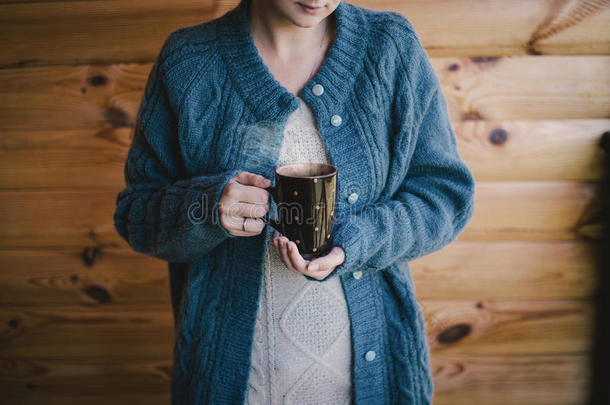 穿着羊毛衫，喝着热茶的女人