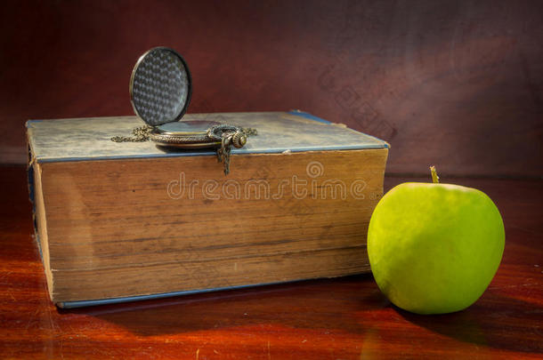 青苹果配古董书和手表。