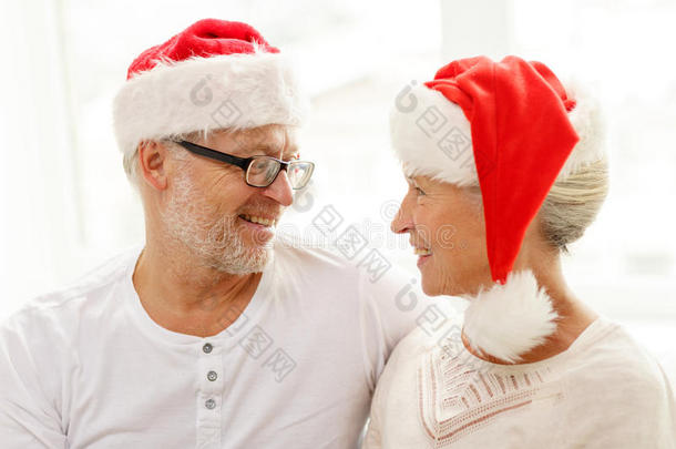 家里戴着圣诞老人帽的快乐老夫妇