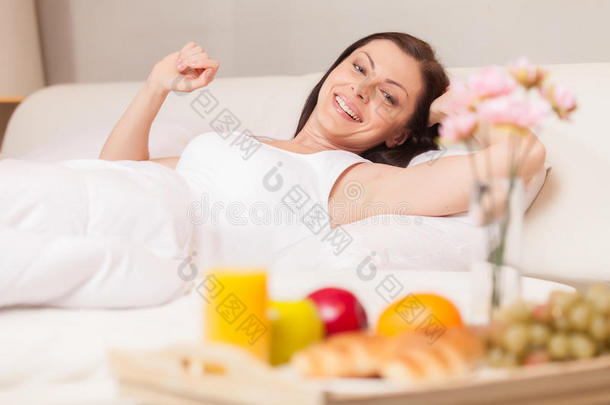 早上在床上舒展筋骨的快乐女人。