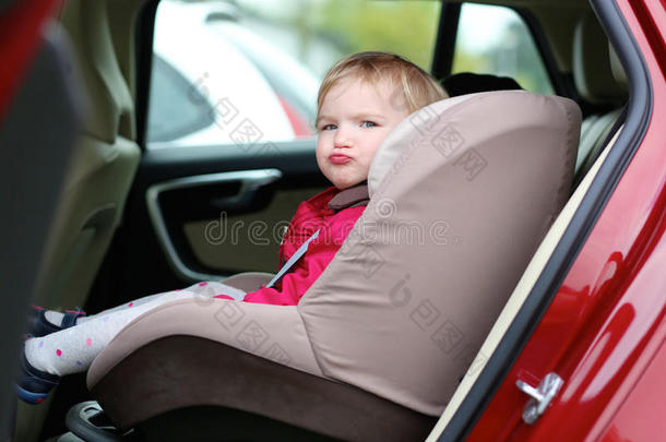 可爱的学龄前女孩坐在车里