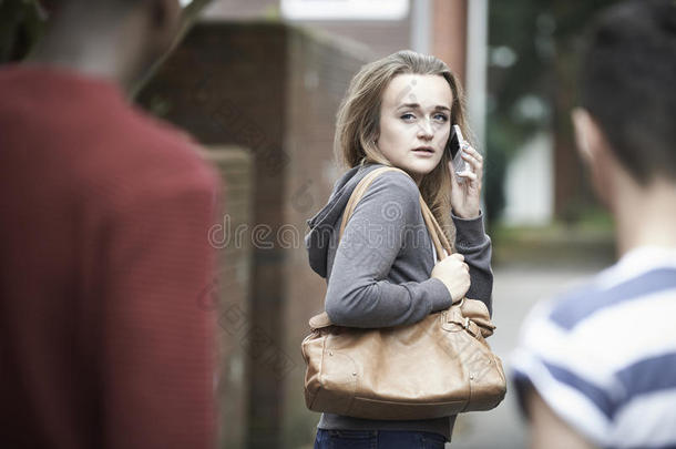 一个十几岁的女孩在回家的路上感到被吓到了就用电话