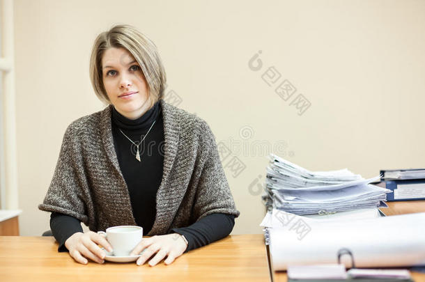 女工程师在办公桌旁，文案室，端着茶杯