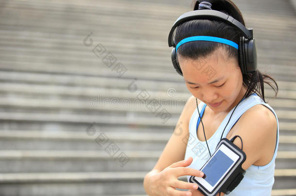 跑步运动员用耳机从智能手机mp3<strong>播放器</strong>收听<strong>音乐</strong>