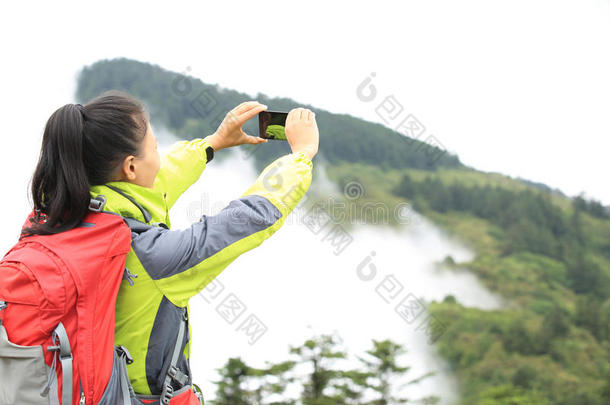 女徒步旅行者用手机拍照