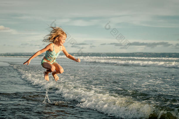 白天在海滩上奔跑的小女孩