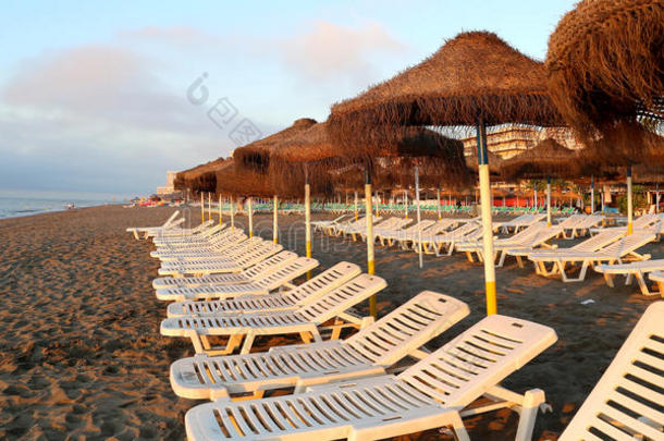 沙滩躺椅和沙滩伞在孤独的沙滩上