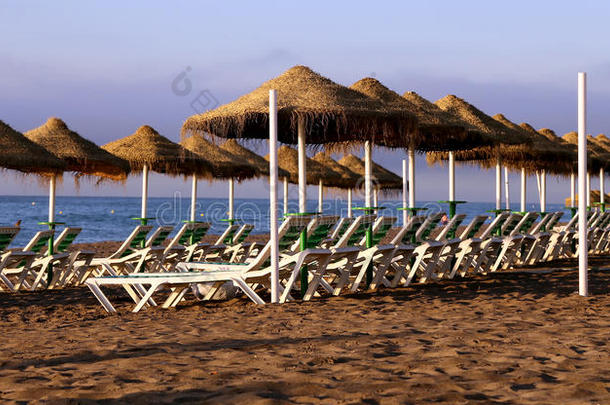 沙滩躺椅和沙滩伞在孤独的沙滩上