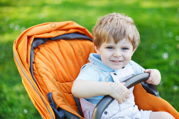 一个可爱的<strong>白人小孩</strong>坐在婴儿车里，两岁