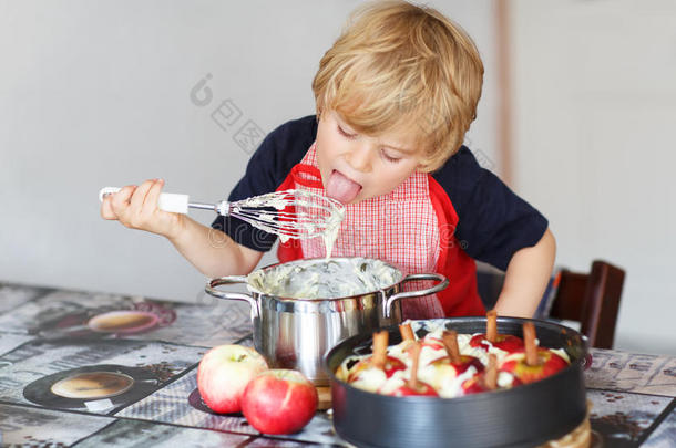 可爱的小男孩在家里的厨房里帮忙烤苹果派
