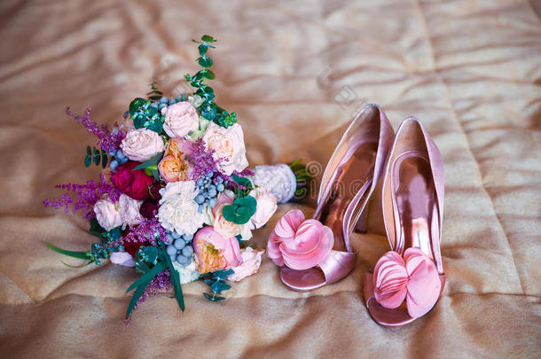 新娘早上穿粉色的结婚饰品。新娘的结婚花束和鞋子。