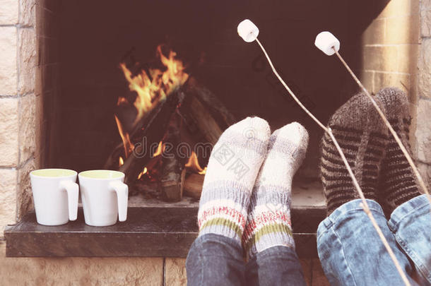 一对夫妇在壁炉前取暖的脚
