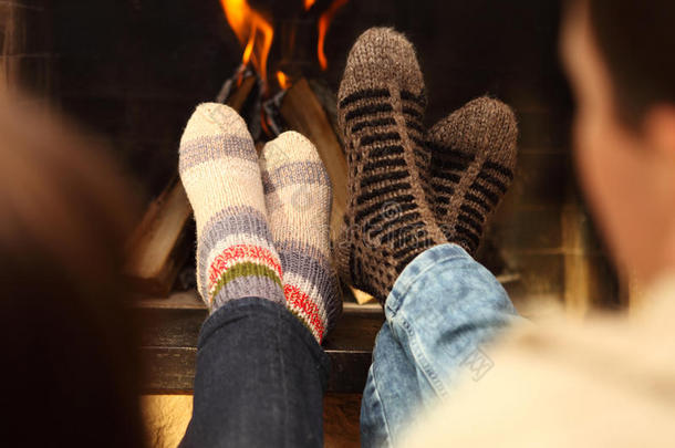 冬天在壁炉前穿袜子的夫妇的腿