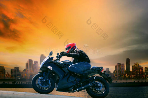 年轻人和安全服骑着大摩托在美丽的<strong>昏暗天空</strong>和城市场景中复制空间