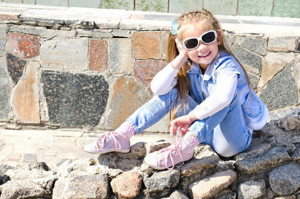 可爱的小女孩坐在石头上
