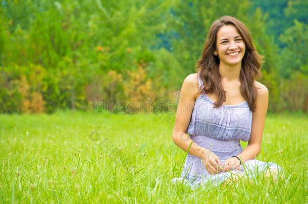 快乐的女人坐在草地上