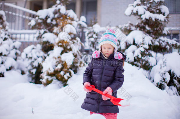 可爱的小女孩在铲雪