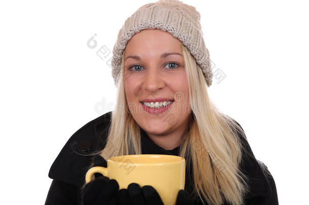 年轻的金发女人在冬天喝茶