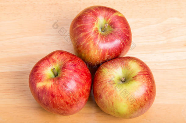 木头桌子上有三个红苹果