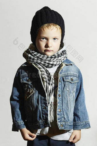 戴着围巾的时髦小男孩牛仔裤。冬天时尚。时尚孩子。孩子戴着黑帽子图片