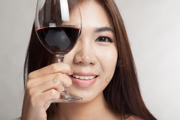 美丽的亚洲女人捧着一杯红酒