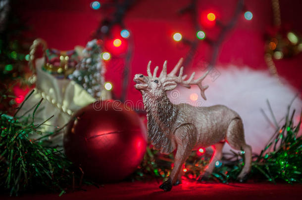 麋鹿玩具圣诞球花环金箔模糊在红色背景
