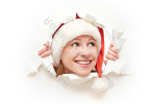 快乐的女人，戴着圣诞帽，从一张撕破的白纸海报上窥视