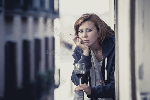 忧郁症少女在阳台外喝酒