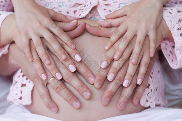 孕妇<strong>双手抱</strong>着肿胀的肚子的特写镜头