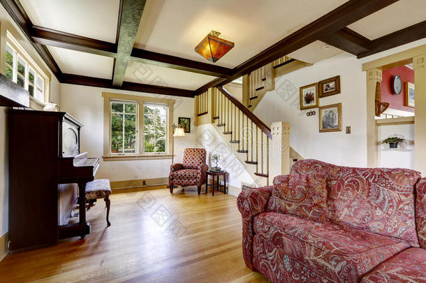 带古董钢琴和舒适的红色沙发的家庭客房