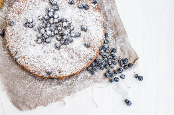 蓝莓蛋糕配新鲜蓝莓和糖粉，白色表面为米色面料
