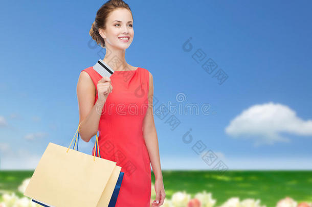 微笑的女人拿着购物袋和塑料卡