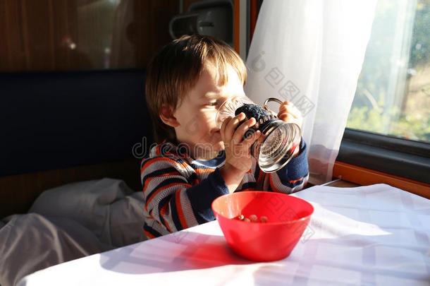小男孩在飞驰的火车上喝茶