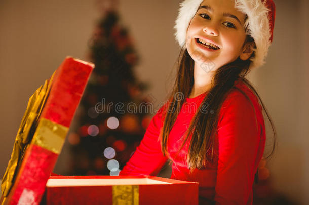 喜庆的小女孩打开一个发光的圣诞礼物