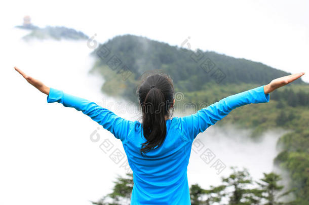 欢呼雀跃的徒步妇女欣赏山顶美景
